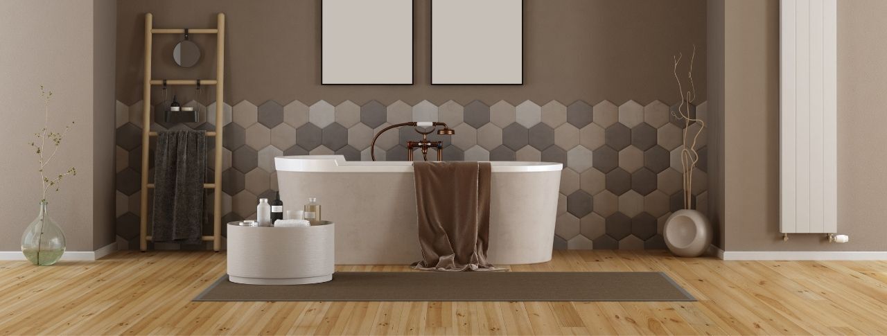 Braunes Bad mit Hexagon-Fließen an der Wand und Fliesen in Holzoptik am Boden. Vor der Wand steht eine freistehende Badewanne.